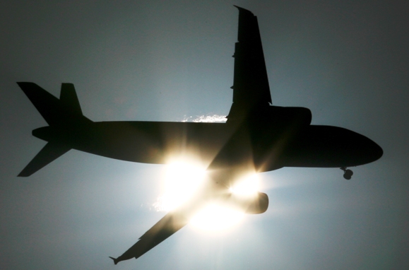 A passenger aircraft is silhouetted against the setting sun in New Delhi.