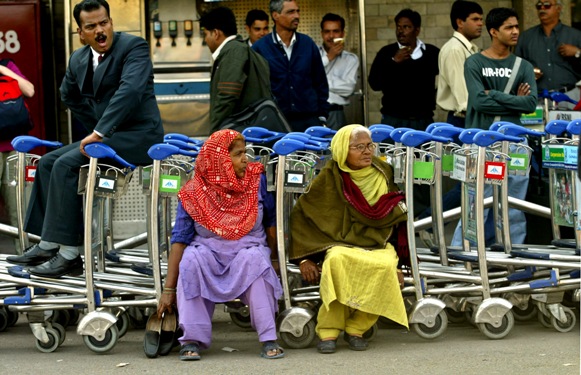 Employees of Airports Authority of India rest on trolleys during a protest in New Delhi.