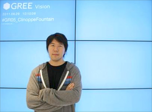Gree Chief Executive Officer Yoshikazu Tanaka poses at his company's lobby.
