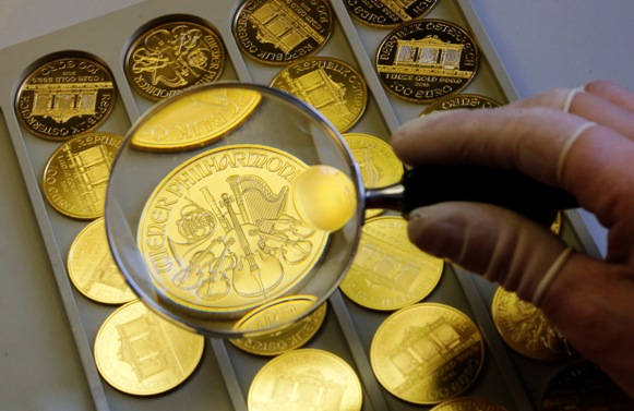A worker at the Austrian Mint checks a gold Vienna Philharmonic bullion coin.