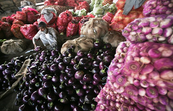 A vendor waits for customers at a wholesale vegetable market on the outskirts of Jammu.