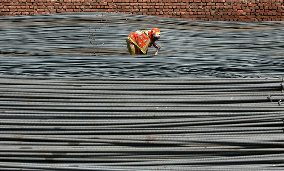 A labourer works inside an iron factory.