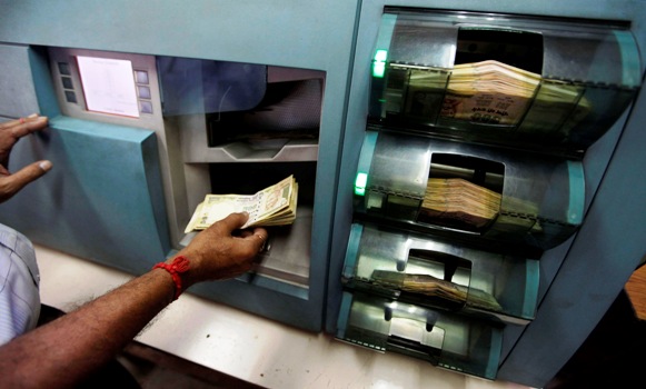 An employee checks Indian currency notes inside a bank in Kolkata.
