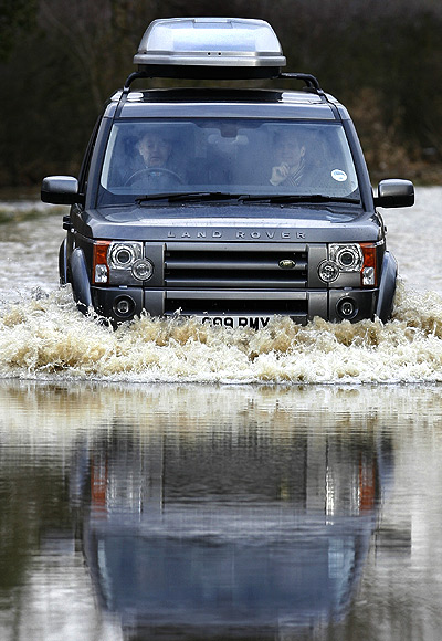 A vehicle is driven through flood waters.