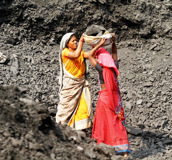 Labourers carry coal at a stockyard of an underground coal mine in the Mahanadi coal fields at Dera, near Talcher town in Orissa.