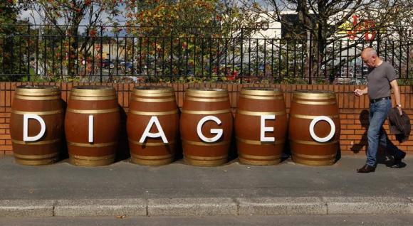 A man walks past barrels outside the Diageo Shieldhall facility near Glasgow, Scotland.