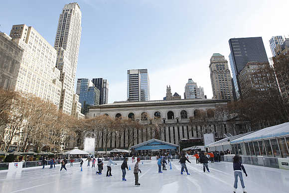 Children rush out onto a freshly resurfaced ice rink set up in Bryant Park, New York City, United States.