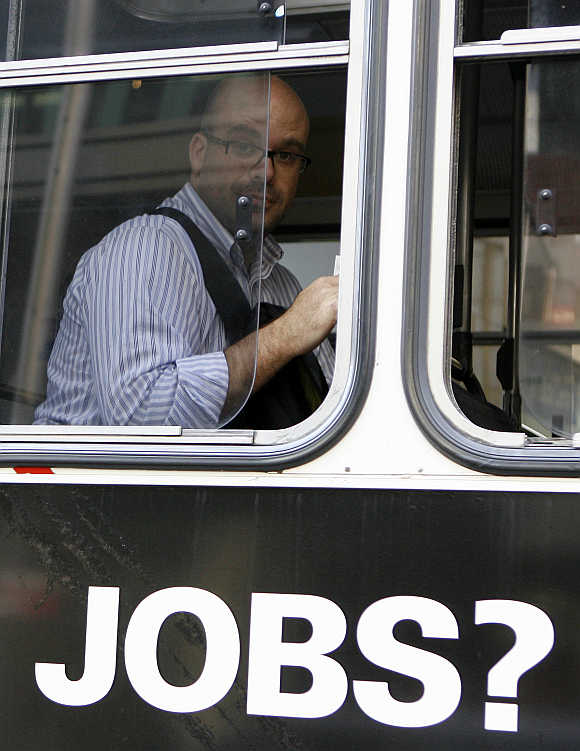 A man sits in a bus with an advertisement for jobs in central Sydney, Australia.