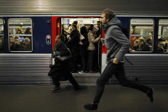 Commuters run to catch a train at Gare Saint Lazare station in Paris, France.