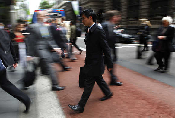 Office workers walk during morning peak hour in central Sydney, Australia.