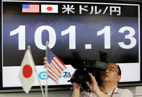 A TV cameraman films in front of a monitor displaying the Japanese yen's exchange rate against the US dollar at a foreign exchange company in Tokyo on May 10, 2013.