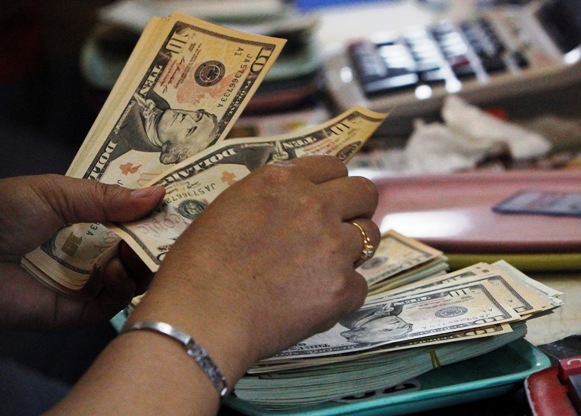 A worker counts US dollar bills inside a money changer in Manila.