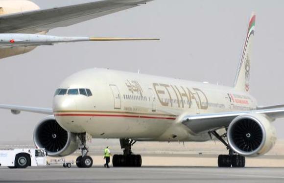 An engineer walks near an Etihad Airways aircraft at Abu Dhabi International Airport.