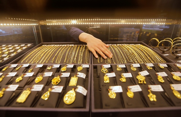 An employee arranges gold jewellery in the counter of a gold shop in Wuhan, Hubei province.