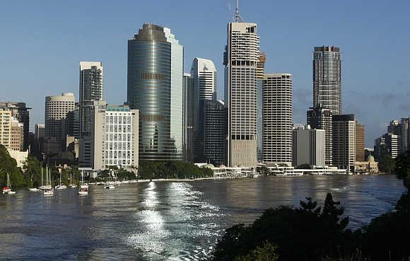 The Brisbane River is seen flowing past the skyline of central Brisbane.