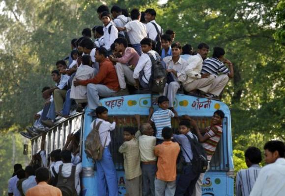 Commuters including school boys travel on a crowded passenger bus during morning rush hours.