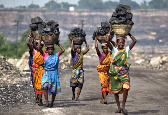 Local women carry coal taken from open cast coal field at Dhanbad district in the eastern Indian state of Jharkhand.