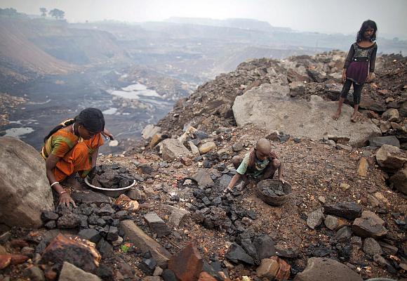 Locals collect coal from an open cast coal field at Dhanbad district in the eastern Indian state of Jharkhand.