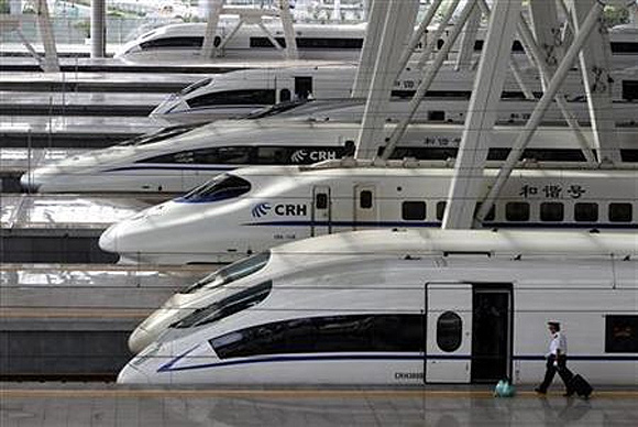 A train employee prepares to enter a CRH (China Railway High-speed) Harmony bullet train at Beijing South Railway Station.