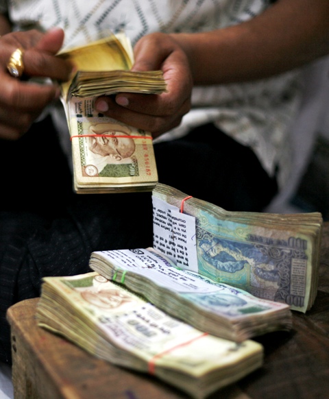 A man counts notes after withdrawing them from a bank in Amritsar.