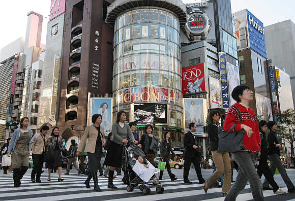People walk in Ginza street in Tokyo, Japan.