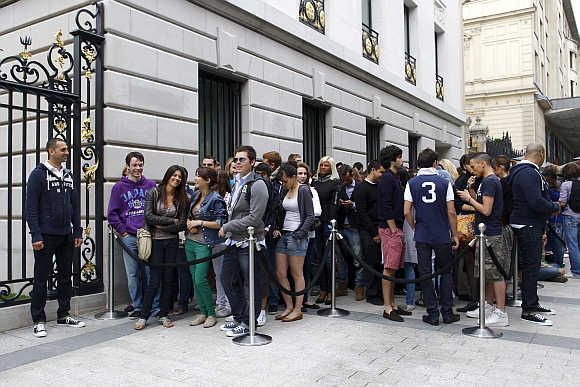 Customers wait outside the Champs Elysees store of clothing retailer Abercrombie & Fitch on its opening day in Paris, France.