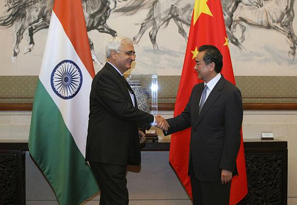 China's Foreign Minister Wang Yi (R) shakes hands with his Indian counterpart Salman Khurshid.