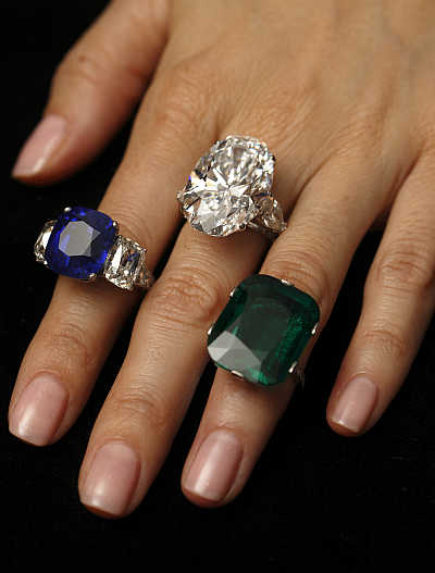 A Christie's member of staff displays, left to right, the 'Star of Kashmir' sapphire ring, a diamond ring (26.24 carats) and a natural cushion-shaped emerald ring (23.28 carats) during an auction preview in Geneva, Switzerland. Items are expected to sell between $2,500,000 to 3,000,000; $2,400,000 to 3,400,000; and $1,300,000 to 1,800,000 respectively when they go into auction.