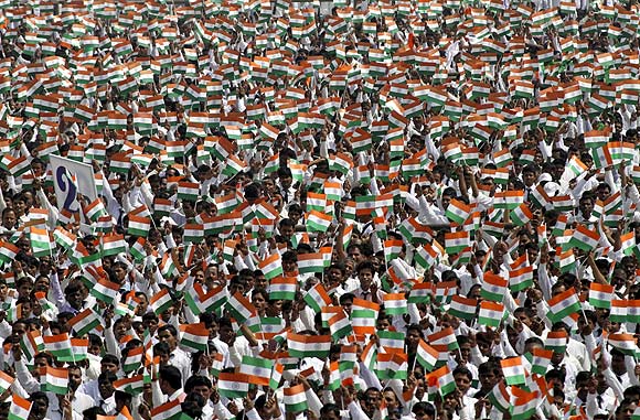Employees of Sahara Group wave miniature national flags before singing India's national anthem in Lucknow.