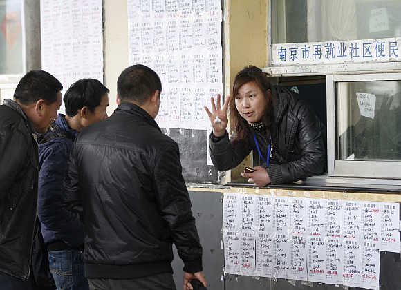 A placement counsellor gestures to job-seekers at a fair in Nanjing, Jiangsu province, China.