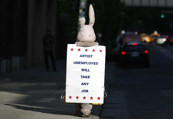 A person dressed as a bunny walks down the street with a sign in New York City.
