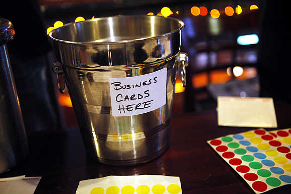 A champagne bucket for members to drop off business cards is displayed as a group of laid-off workers meet during a recruitment event at a pub in New York City.