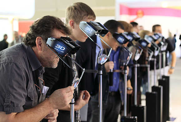 Visitors to Photokina look through 3-D glasses at the booth of Panasonic in Cologne, Germany.
