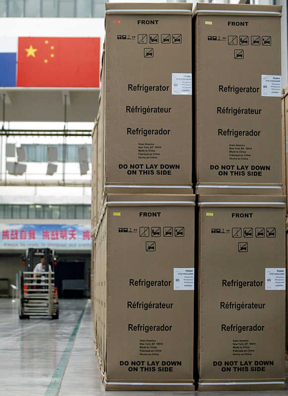 A worker operates a forklift past rows of refrigerators ready for shipment to the United States at Haier factory in China's eastern port city of Qingdao.