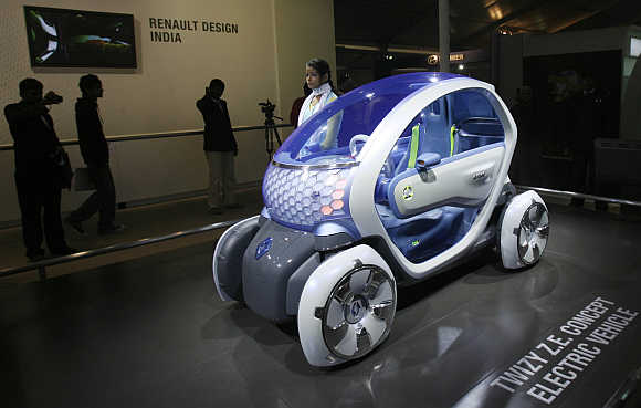A model stands next to Renault's 'Twizy Z. E. Concept Electric Vehicle' at India's Auto Expo in New Delhi.