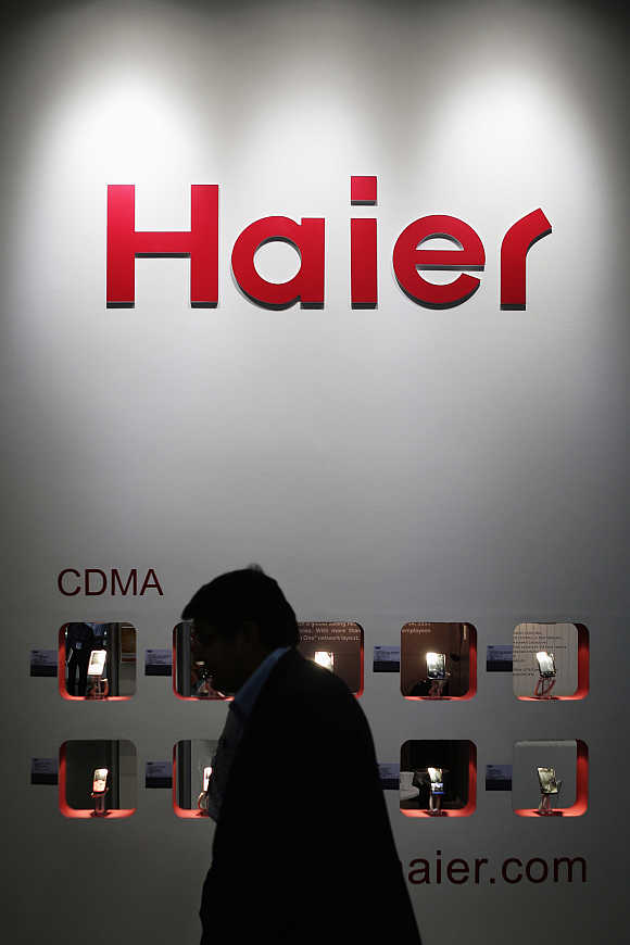 A visitor walks past CDMA mobile phones on display at Haier's exhibition pavilion in Singapore.