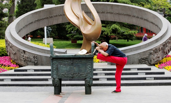 An old man stretches at a park in Beijing.