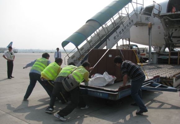 Workers load cargo in Deccan 360 aircraft.