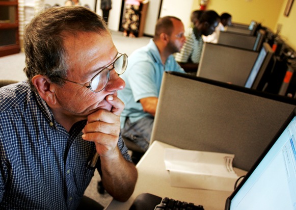 Stephen Battaglia (L) of West Palm Beach, Florida searches for jobs on a computer at Workforce Alliance in West Palm Beach, Florida.