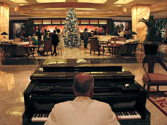 A man plays the piano at the lobby of Taj Mahal hotel in Mumbai.