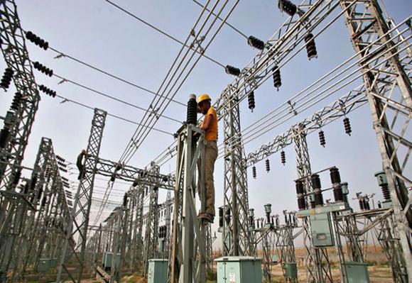 An employee works on electric pylons at a power station.