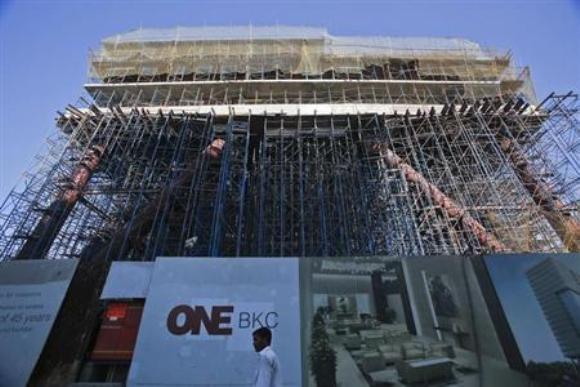 A man walks in front of the under-construction One BKC commercial complex, being built by The Wadhwa Group, in the Bandra-Kurla Complex in Mumbai.