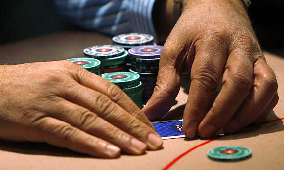 A contestant covers his cards during the Poker Stars tournament in London.