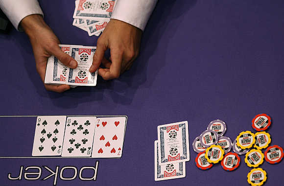A dealer lays a playing card on the table at the World Series of Poker Europe competition at the Empire Casino in London.