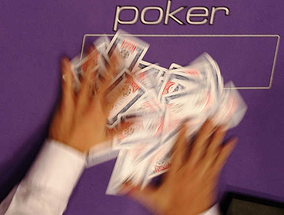 A dealer shuffles playing cards at the World Series of Poker Europe competition at the Empire Casino in London.