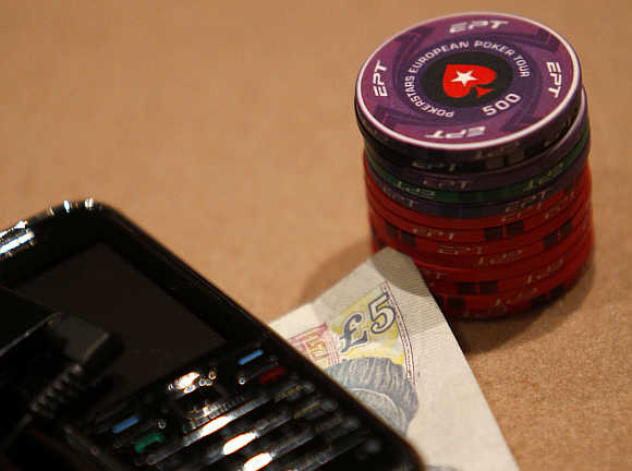 Chips are stacked up next to a five pound note and mobile phone during the Poker Stars tournament in London.
