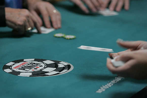 A dealer tosses out a card in the $10,000 buy-in, no limit Texas Hold 'Em main event during the World Series of Poker at the Rio All-Suite Hotel & Casino in Las Vegas, Nevada, United States.