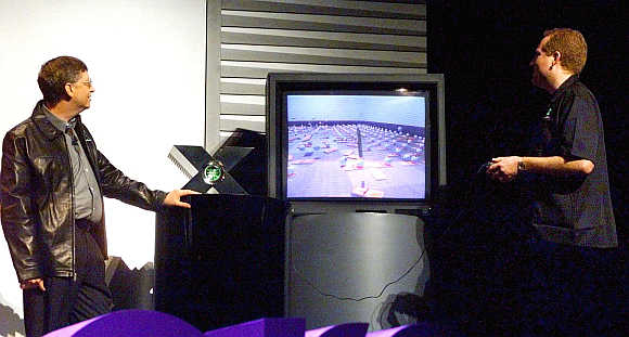 Bill Gates, left, watches as Seamus Blackley, Director of Microsoft's X-Box advanced technology, demonstrates the capabilites of the video game console at the Game Developers Conference in San Jose, California.