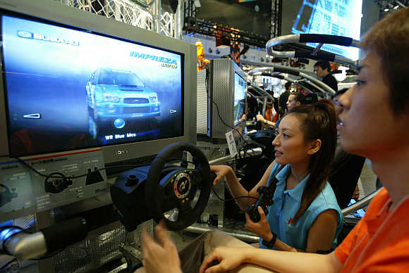 Visitors play Gran Turismo 4 video game on Sony Playstation 2 at Tokyo Game Show in Chiba, Japan.