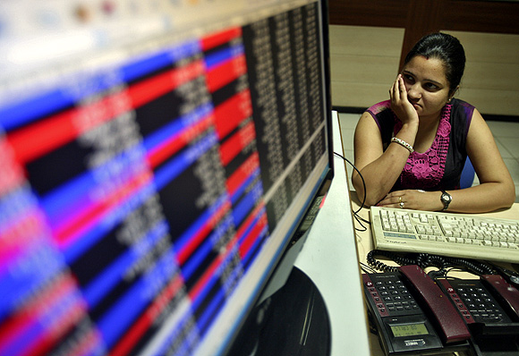 An investor watches the share index at a local share and stock market in Chandigarh.